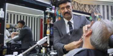 Böyle tıraş görülmedi! Müşterilerini takım elbiseyle tıraş ediyor, işine saygısını hiç kaybetmiyor